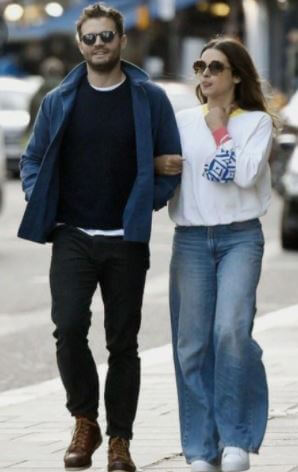 Jim Dornan son Jamie Dornan and daughter in law Amelia Warner walking down the street.